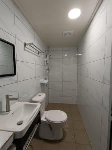 a white bathroom with a toilet and a sink at Home Away Tioman Island in Tioman Island