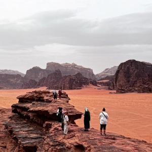 Un groupe de gens debout sur un rocher dans le désert dans l'établissement Bedouin Yoga & Trekking Camp Wadi Rum, à Wadi Rum