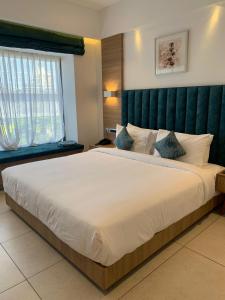 una camera con un grande letto con testiera verde di Daya by Renai a Cochin