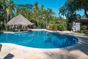una piscina en un complejo con palmeras en Sunset del Mar Beach Resort, en Esterillos Este