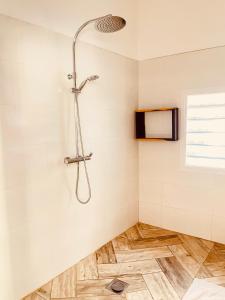 a shower in a bathroom with white tiles at VOVO TELO LODGE in Toliara