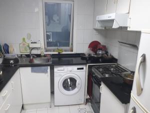 a kitchen with a washing machine and a sink at Daily stay Royal flat in Dubai