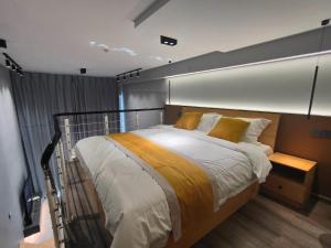a bedroom with a large bed with yellow pillows at Panda ZuoKe Besucher Apartment 熊猫坐客民宿 in Kunming