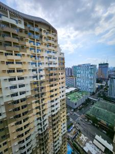 vue d'un immeuble de grande hauteur dans une ville dans l'établissement Brand New Central Convenience Studio Condo with Balcony in Araneta City Cubao, à Manille 13 autres photos