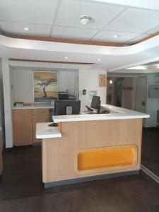 um escritório com um balcão de recepção com um banco laranja em SUN1 PRETORIA em Pretoria