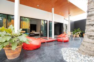 an outdoor patio with orange bean bags and a table at PP@Hotel Rangsit in Pathum Thani