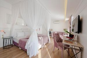 a bedroom with a bed with curtains and a desk at Nun By Laren Hotels in Antalya