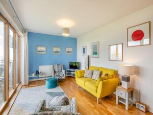 - un salon avec un canapé jaune et une télévision dans l'établissement Seaview, à Parkeston