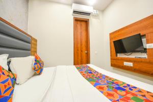 a bedroom with a bed with a flat screen tv at FabExpress Royal MG in Ludhiana