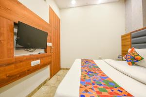 um quarto com uma cama e uma televisão de ecrã plano em FabExpress Royal MG em Ludhiana