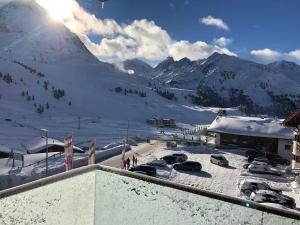 a view of a snow covered mountain with cars parked at Kühtai Alpensuites in Kühtai
