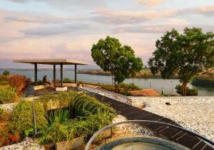a person sitting on a bench next to a hot tub at SaffronStays Avni in Trimbak