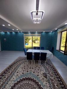 een eetkamer met een tafel en stoelen en een groot tapijt bij Riverside Villa in Gabala