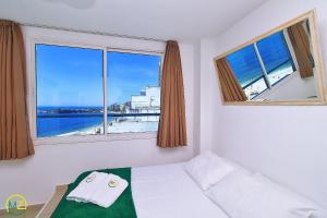 um quarto com uma cama e uma janela com vista em Incrível cobertura c/ jacuzzi & vista frontal mar no Rio de Janeiro
