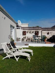 a patio with two white chairs and a table at Lor's Place in Mount Road