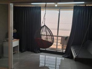 una habitación con un columpio colgando de una ventana en D ocean view, en Surat