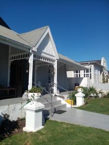 a white house with a porch and a driveway at Lor's Place in Mount Road