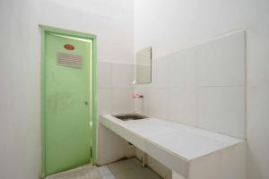 ein Badezimmer mit einer grünen Tür und einem Waschbecken in der Unterkunft Lyfriska Residence Lampung RedPartner in Lampung