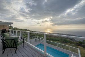 a house with a balcony with a view of the ocean at The Pineapple Palace in Papa Bay Estates
