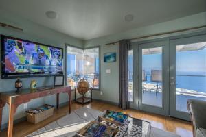 een woonkamer met een groot scherm en glazen schuifdeuren bij The Pineapple Palace in Papa Bay Estates