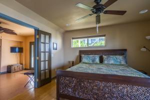 een slaapkamer met een bed met een plafondventilator bij The Pineapple Palace in Papa Bay Estates +59 foto's