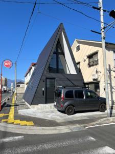 甲府的住宿－TRIGON HOUSE HOTEL KOFU，停在大楼前的货车