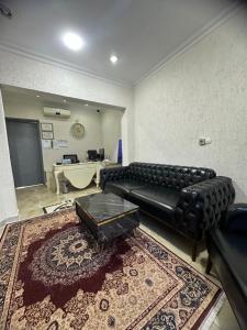 sala de estar con sofá de cuero negro y alfombra en BİG ORANGE HOTEL en Estambul