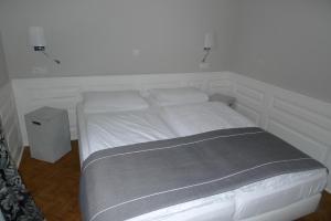 ein weißes Bett in einem Schlafzimmer mit einer weißen Wand in der Unterkunft Apart-Hotel Heiligenthaler Hof in Landau in der Pfalz