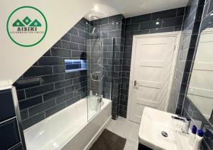 bagno con vasca, lavandino e doccia di FW Haute Apartments at Enfield, Pet Friendly Ground Floor 3 Bedrooms and 2 Bathrooms Flat with King or Twin beds with Garden and FREE WIFI and FREE PARKING a Londra