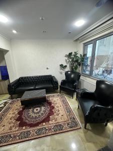 a living room with a couch and two chairs and a rug at BİG ORANGE HOTEL in Istanbul