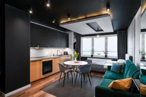 eine Küche und ein Wohnzimmer mit einem Sofa und einem Tisch in der Unterkunft Apartaments 24 Premium Green in Breslau