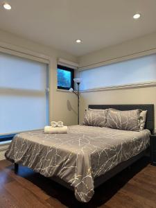 ein Schlafzimmer mit einem Bett mit einer silbernen Bettdecke in der Unterkunft A Tiny House Near UBC 温哥华UBC小别墅 in Vancouver