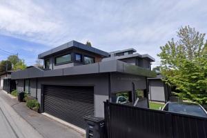 una casa negra con un coche aparcado delante de ella en A Tiny House Near UBC 温哥华UBC小别墅, en Vancouver