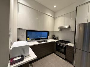 a kitchen with white cabinets and a sink and a refrigerator at A Tiny House Near UBC 温哥华UBC小别墅 in Vancouver