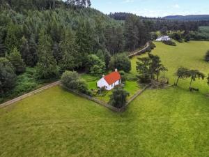 a white house with a red roof on a green field at St Orans in Rafford