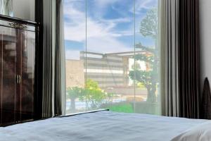 a bedroom with a bed and a large window at Grand Villa Oasis in Dhaka