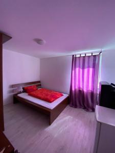 a bedroom with a bed with red sheets and a window at Gasthaus Wendischbrome in Nettgau