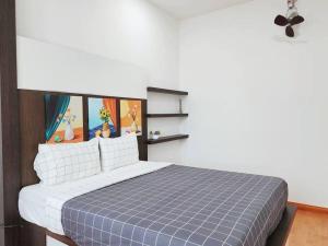 a bedroom with a bed with a blue blanket at Tambun lost world luxury villa 5BR/20 pax/mahjong/karaok/bbq/garden events in Tambun