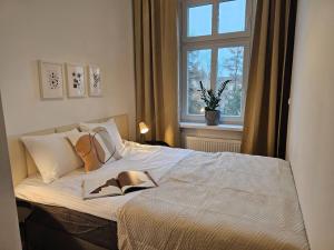 um quarto com uma cama com um livro em URBAN APARTMENTS PREMIUM No12 Chorzów, Katowice with PRIVATE PARKING em Chorzów
