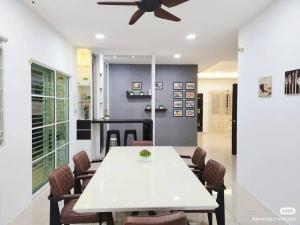 a dining room with a white table and a ceiling fan at Tambun lost world luxury villa 5BR/20 pax/mahjong/karaok/bbq/garden events in Tambun