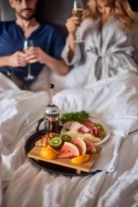 a man and a woman in bed with a plate of food at Naantali Spa Hotel in Naantali
