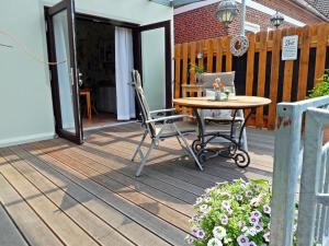 a wooden deck with a table and chairs on it at Landgang I 90qm² mit Garten in Elsfleth