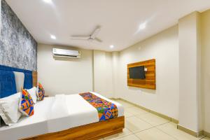 1 dormitorio con 1 cama y TV en la pared en FabHotel Orio I en Ludhiana