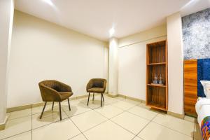 twee stoelen in een kamer met een slaapkamer bij FabHotel Orio I in Ludhiana