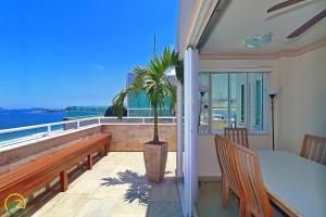 d'un balcon avec une table et un palmier. dans l'établissement Incrivel cobertura frente mar com terraço, à Rio de Janeiro