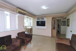 sala de estar con 2 sillas y TV de pantalla plana en Incrivel cobertura frente mar com terraço, en Río de Janeiro