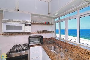 cocina con fregadero, microondas y el océano en Incrivel cobertura frente mar com terraço, en Río de Janeiro
