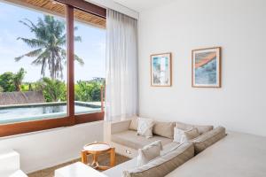 a living room with a couch and a large window at Pagi Villas by Betterplace in Canggu