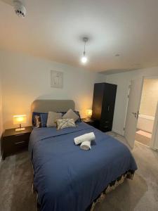 a bedroom with a large blue bed with two lamps at Flat close to Manchester Picadilly station in Manchester