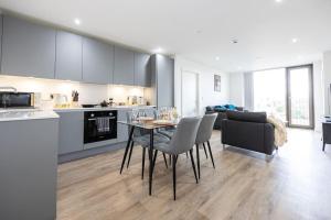 a kitchen and living room with a table and chairs at Flat close to Manchester Picadilly station in Manchester